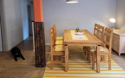 een eettafel met een zwarte kat op de vloer bij Ferienwohnung nahe der Nordsee in Holm