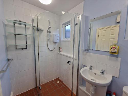 ein Bad mit einer Dusche und einem Waschbecken in der Unterkunft 28 Broadside Holiday Chalet near Broads & Beaches in Stalham