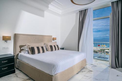 a bedroom with a bed with a view of the ocean at Palazzo Murrano - Adults Only in Vico Equense