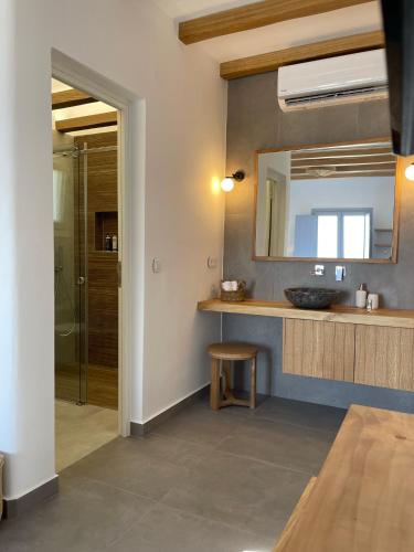 a bathroom with a sink and a mirror at SOHOROS suites in Schinoussa