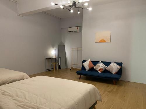 Zimmer mit einem blauen Sofa und einem Bett in der Unterkunft Lemon Olive Stylish Townhouse in Kota Bharu