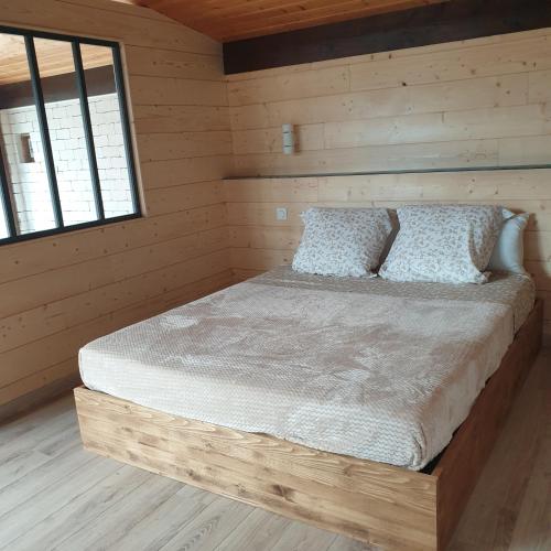 a bedroom with a bed in a log cabin at Appartement Grésival in Chapareillan