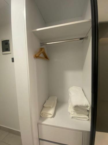 a closet with two white towels on a shelf at Kass Towers, Studio Apartment in Accra