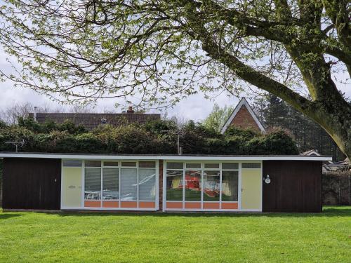 a house with a lot of windows and a tree at 169 Broadside Holiday Chalet near Broads & Beaches in Stalham