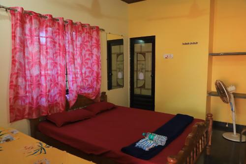 a bedroom with a bed and a red curtain at Ruvi Beach front Ac rooms in Gokarna