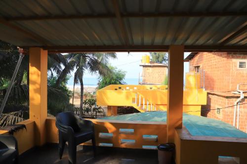 a balcony with a view of a yellow building at Ruvi Beach front Ac rooms in Gokarna