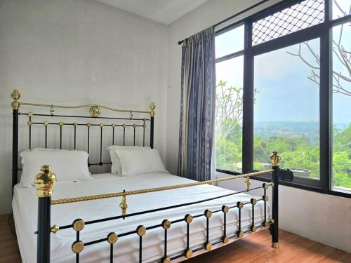 a bedroom with a bed and a large window at Villa Montaview Puncak (Mountain View Cottage) in Gadok 1