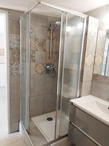 une douche avec une porte vitrée dans une salle de bain dans l'établissement Studio Avignon Intra Muros full equipée R+2, à Avignon