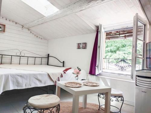 une chambre avec un lit, une table et une fenêtre dans l'établissement Studio Avignon Intra Muros full equipée R+2, à Avignon