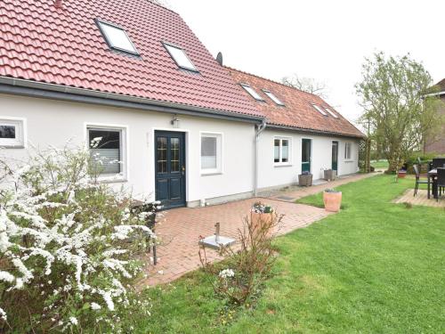 a white house with a red roof and a yard at Lovely Apartment in Stellshagen with Garden in Stellshagen