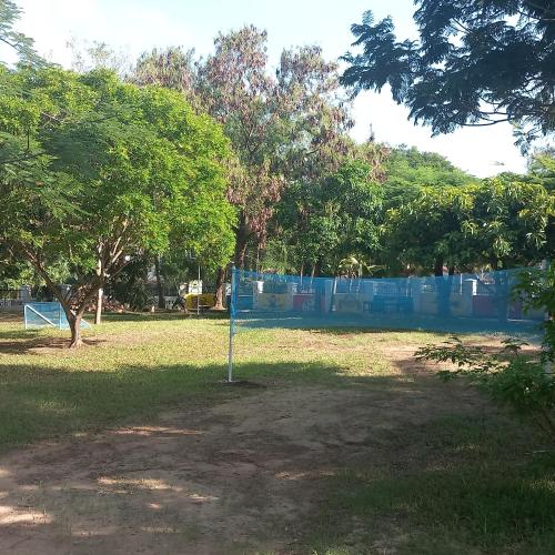 a park with trees and a blue fence at Maasai Barracks Resort in Mombasa