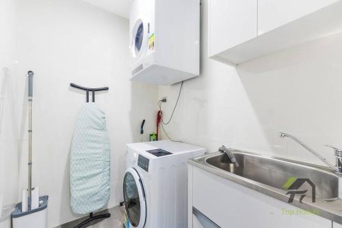 a kitchen with a washing machine and a sink at Sunshine 2 Bed home in Olympic Park in Sydney