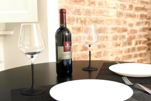 een fles wijn en twee glazen op een tafel bij Central Loft in Milaan