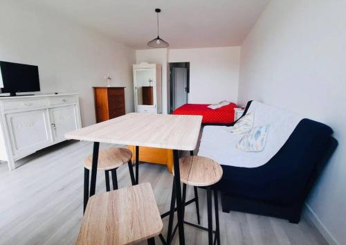 une pièce avec une table et des chaises et une chambre dans l'établissement Appartement vue mer, à Calais