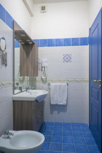 a blue and white bathroom with a sink and a mirror at Hotel Centro Congressi Polo Nautico in Salerno