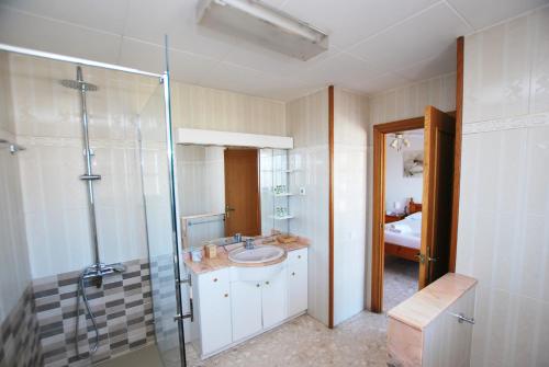 濱海卡夫雷拉的住宿－Ca l'Enric，一间带水槽和玻璃淋浴的浴室