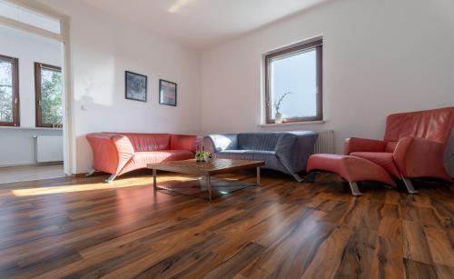 a living room with red couches and a table at Herbst in Ostseebad Karlshagen