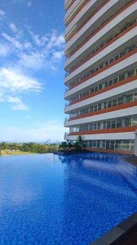 a large building with a swimming pool in front of it at Montage Villa near Beach with Golf View in Nongsa
