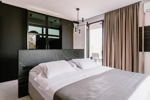 a bedroom with a large bed and a large window at Domina in Vodice