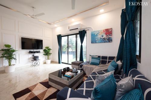 a living room with a couch and a tv at EKOSTAY - Casa Paradiso in Alibaug
