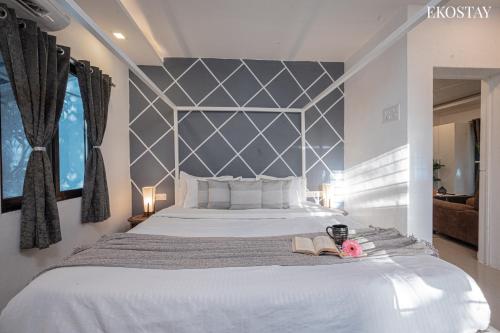 a bedroom with a large bed with a gray headboard at EKOSTAY - Casa Paradiso in Alibaug