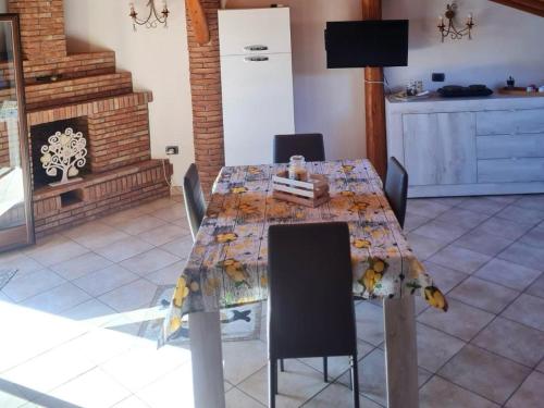 een eetkamer met een tafel met stoelen en een open haard bij Casa vacanza LMT in Aci Catena