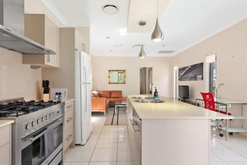 a kitchen and living room with a stove at Impeccable Modern 1 Bedroom Apartment ~ Taringa in Brisbane