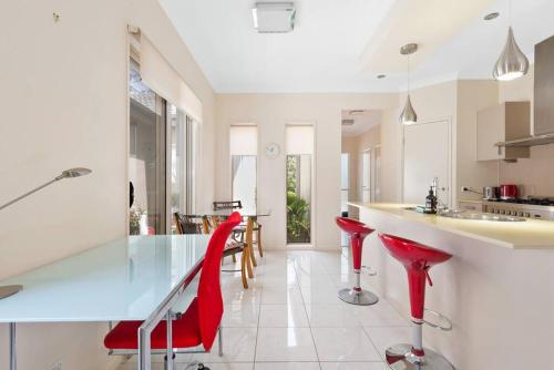 a kitchen with red bar stools and a counter at Impeccable Modern 1 Bedroom Apartment ~ Taringa in Brisbane