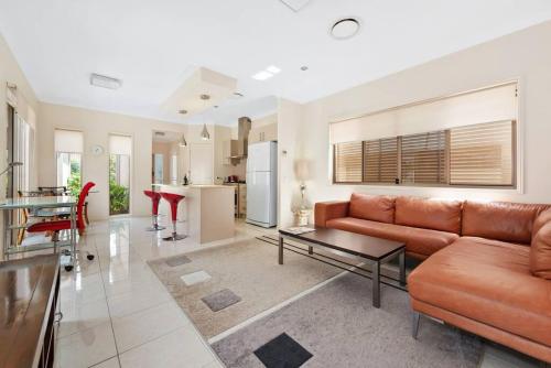a living room with a couch and a table at Impeccable Modern 1 Bedroom Apartment ~ Taringa in Brisbane