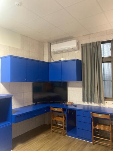 una cocina azul con armarios azules y 2 sillas en 夏綠房, en Fengyuan