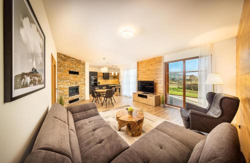 a living room with a couch and two chairs at Pihel Apartments in Nový Bor