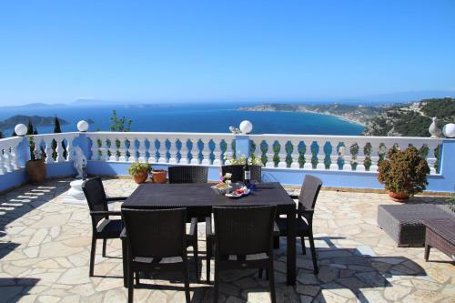 a table and chairs on a patio with a view of the ocean at Villa Bettina 1st floor in Afionas