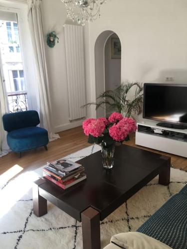 - un salon avec un vase de fleurs roses sur une table dans l'établissement Elégant 4-room apartment near Arc de Triomphe and Palais des Congrès, à Paris