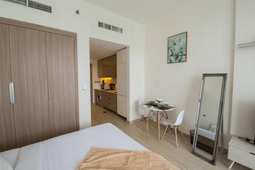 1 dormitorio con cama, mesa y espejo en Cozy Studio with Burj view, en Dubái