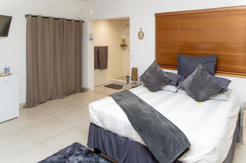 a bedroom with a large bed with pillows on it at The Little Gem in Clanwilliam