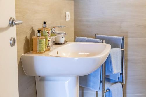 um lavatório branco numa casa de banho com toalhas azuis em Ca de l'Angelon em Brenzone sul Garda