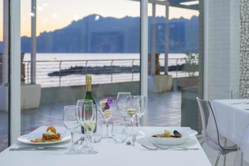 a table with wine glasses and a bottle of wine at Hotel Centro Congressi Polo Nautico in Salerno