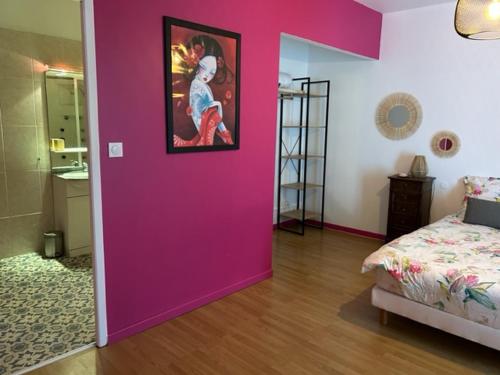 een roze muur in een slaapkamer met een bed bij Auberge des Avalats in Albi