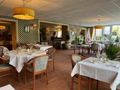 een restaurant met tafels en stoelen met witte tafelkleden bij Auberge des Avalats in Albi