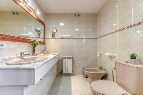 een badkamer met 2 wastafels en een toilet bij Mirador 31 Roses - Immo Barneda in Roses