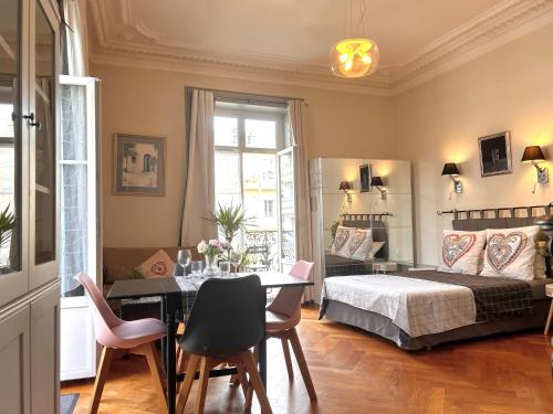 sypialnia z łóżkiem, stołem i krzesłami w obiekcie Carla's Residences F1 Hyper Centre w Aix-les-Bains