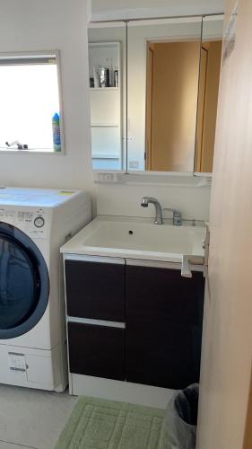 a kitchen with a washing machine and a sink at MiShe主题南行徳民宿 in Tokyo