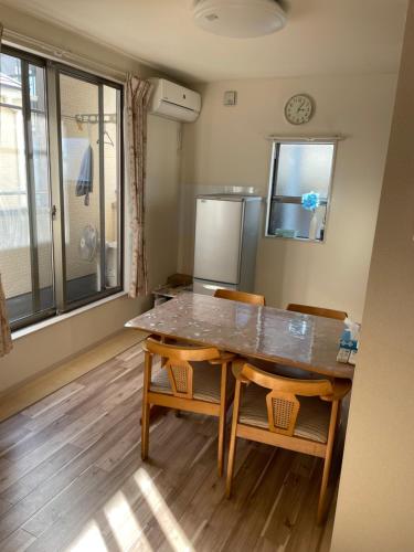 a kitchen with a table and chairs and a refrigerator at MiShe主题南行徳民宿 in Tokyo
