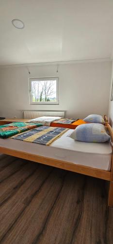 uma cama grande num quarto com piso em madeira em Apartmani Roki em Tuzla