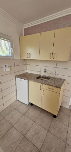 an empty kitchen with a sink and a counter at Apartmani Roki in Tuzla
