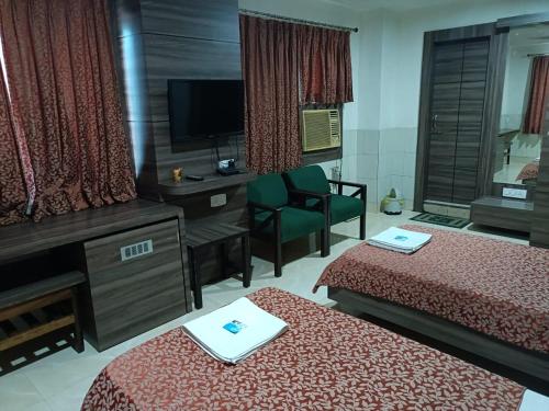 a hotel room with two beds and a television at Hotel Orchid in Guwahati