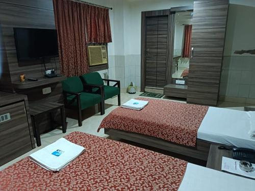 a hotel room with two beds and a television at Hotel Orchid in Guwahati