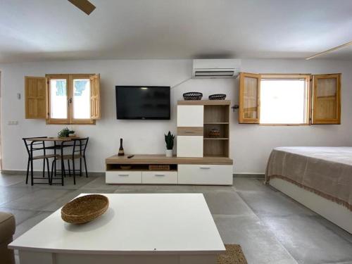 La casita de la abuela María في ألميريا: غرفة معيشة مع سرير وتلفزيون
