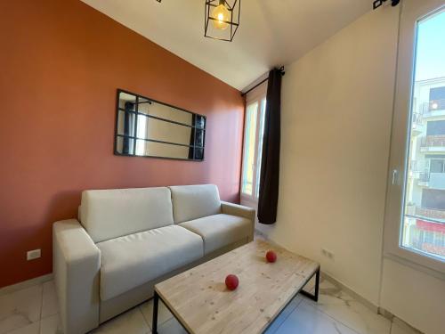un salon avec un canapé blanc et une table dans l'établissement Appartement centre ville, à Nice