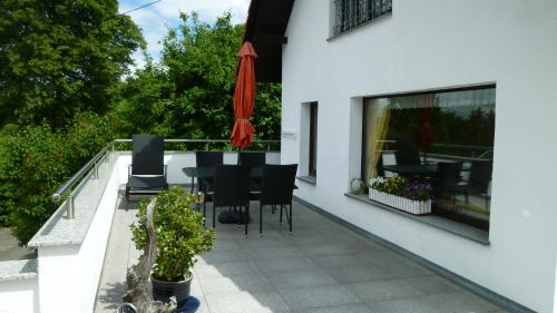 a balcony with a table and chairs and an umbrella at Ferienwohnung Frenzel in Kurort Gohrisch